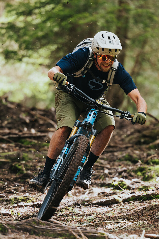 Rider on a Bosch-powered eMTB climbing a forest trail